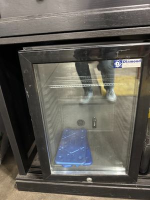 a glass door that is open to show a blue container