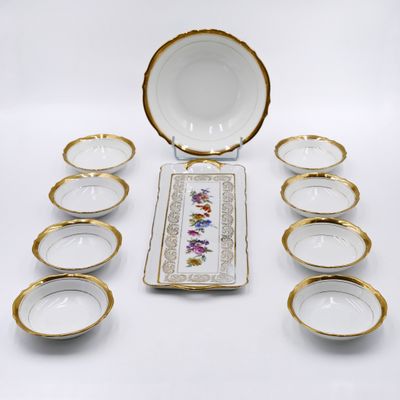 a group of porcelain bowls and plates with gold rims