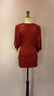 robe rouge à paillettes posée sur un présentoir pour mannequin