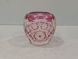 un saladier en verre rose posé sur une table blanche