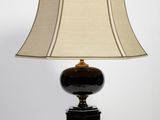 une photo d'une lampe de table avec un pied noir et un abat-jour beige