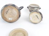 three pieces of pottery sitting on top of a table next to each other