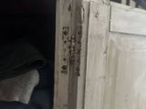 a wooden cabinet with a bunch of clothes inside of it