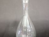 a clear glass bottle with a flower on top of it