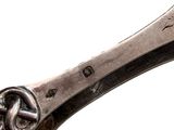 a silver spoon with a knot on it on a white background