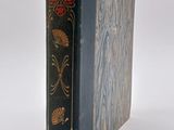 an old book sitting on top of a white table next to a white wall