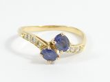 a yellow gold ring with two blue sapphires and diamonds