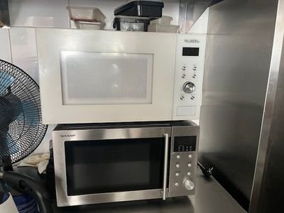 a microwave and a fan in a small kitchen