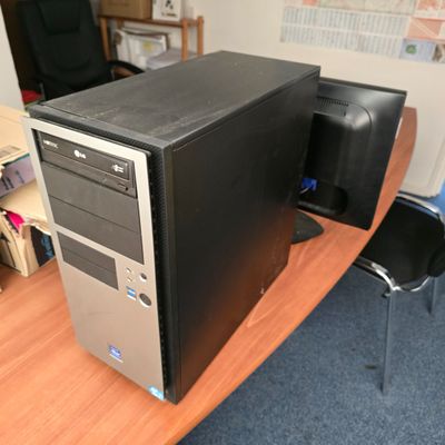 un ordinateur de bureau posé sur un pupitre en bois