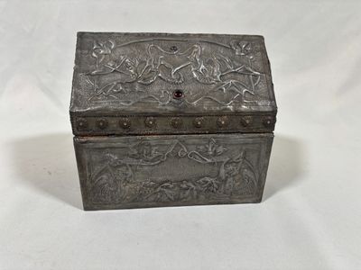 an old metal box with a floral design on the lid