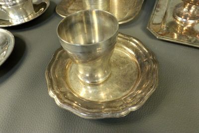 a silver plate with a silver cup and saucer on it