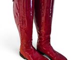pair of red boots on a white surface with a white background
