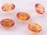 a group of five orange sapphires sitting on top of a white surface