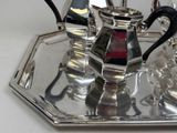 a silver tray with a silver tea set on it