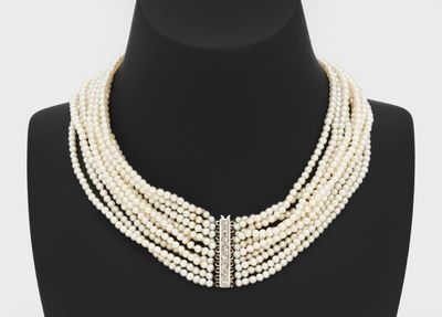 a close up of a white pearl necklace on a mannequin