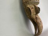 a wooden mask hanging on a wall on the wall