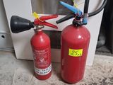 two fire extinguisors sitting next to each other on the floor