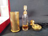 a small bottle of perfume next to a small bottle of perfume