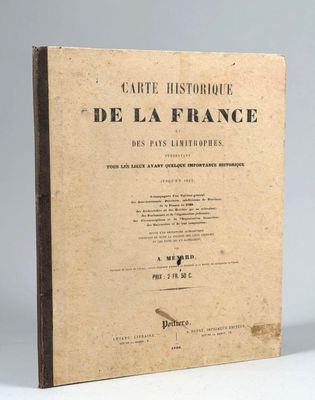 un vieux livre posé sur une table à côté d'un mur blanc