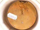 a close up of a clock in a white bowl