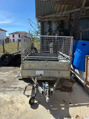 une petite remorque équipée d'une cage à l'arrière