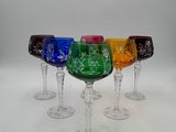 six wine glasses with different colored designs are lined up in a row