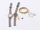 a watch, bracelet, and ring on a white surface