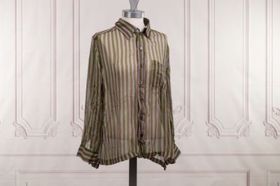 une chemise rayée posée sur un mannequin devant un mur blanc