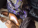 a pile of shoes and a scarf on a bed