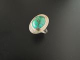 une bague en argent ornée d'une turquoise au centre
