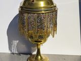 a gold urn with beads and fringes on it