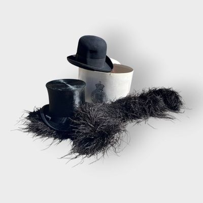two hats and a feather on a white table