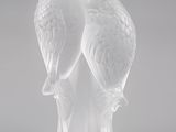 une sculpture en verre transparent représentant deux oiseaux perchés sur une branche