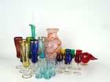 de nombreux vases et verres en verre de différentes couleurs sur la table