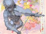 a statue of a boy playing a violin in front of a painting