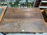 a wooden table with a glass case in the background