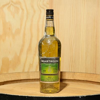 a bottle of chartreuse sitting on top of a barrel