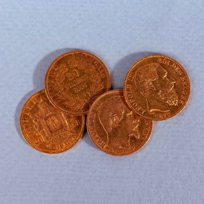 Quatre types différents de pièces de monnaie britanniques sont représentés sur un fond blanc