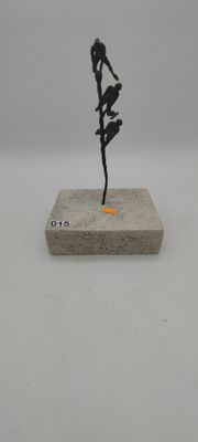 statue d'une femme tenant une fleur, posée sur un socle, sur une surface blanche