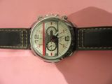 un gros plan d'une montre-bracelet posée sur une surface rose