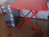 une petite table rouge avec une chaise pliante rouge à côté