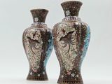 two vases sitting side by side on a white surface