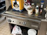 un homme debout dans la cuisine, en train de préparer un repas sur la cuisinière