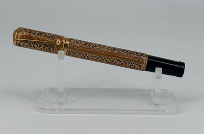 une image représentant un stylo posé sur un support transparent, sur une surface blanche