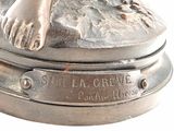 a silver statue of a woman with her foot on a rock