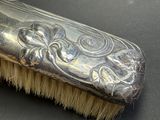 a silver brush that is sitting on top of a table
