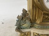 a gold clock sitting on top of a white table