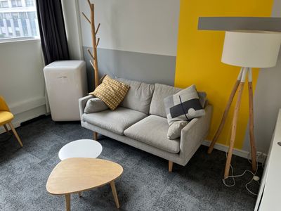 a couch and a table in a room with a yellow wall