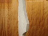 a sculpture of a sailboat on a pedestal in front of a wooden wall
