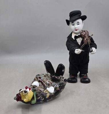 une figurine représentant un homme jouant du violon à côté d'un poisson